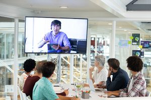 Rear view of diverse business people attending video conference at conference room in a modern office